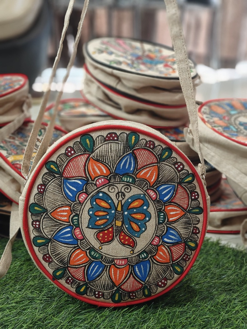 Round jute sling bag with butterfly mandala artwork