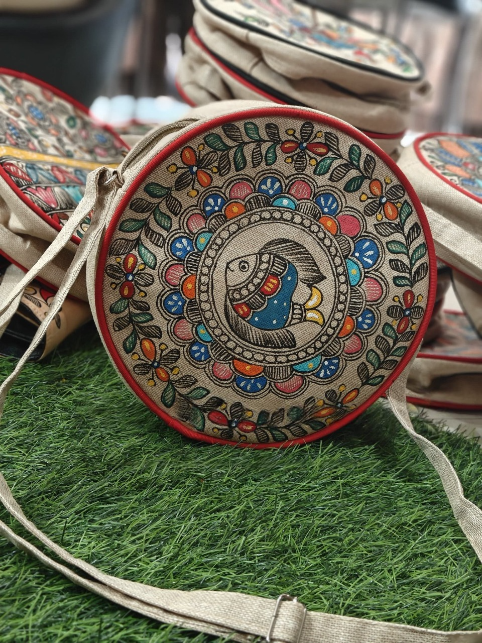 Madhubani round sling bag with fish motif on grass